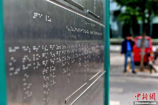 5月25日，北京市西直門公交車站臺(tái)上，一座用盲文“書寫”站點(diǎn)的不銹鋼盲文公交站牌悄然建成。在站牌下方圍繞站牌鋪設(shè)的盲人步道與站牌的結(jié)合方便了盲人的乘車出行。中新網(wǎng)記者